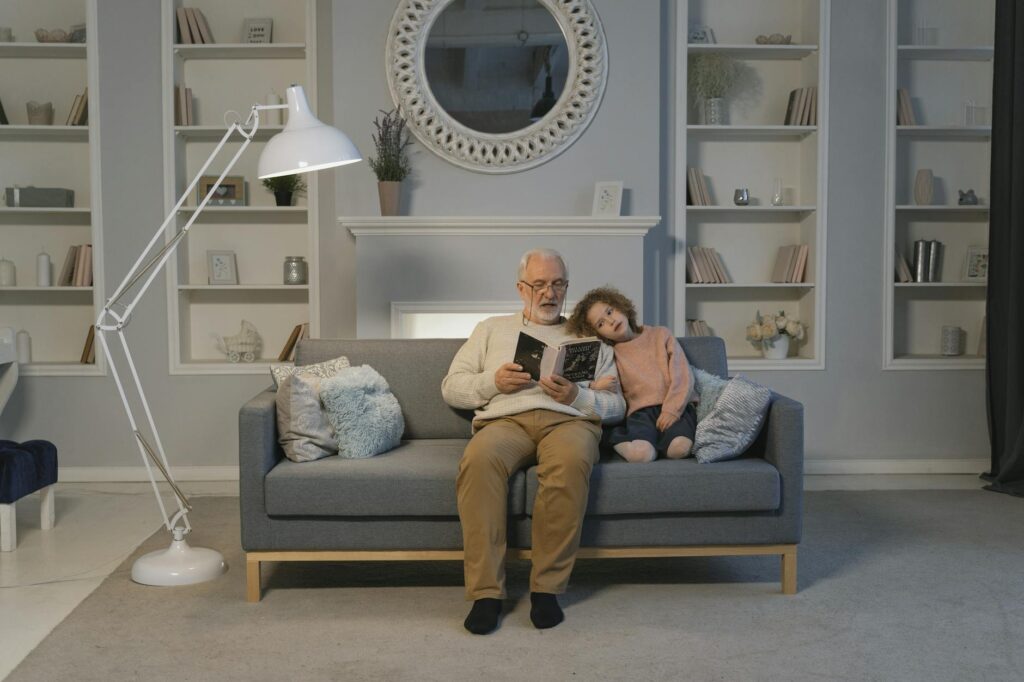 A child reading a book with their grandparent in a cozy living room — help grandchildren succeed school Utah