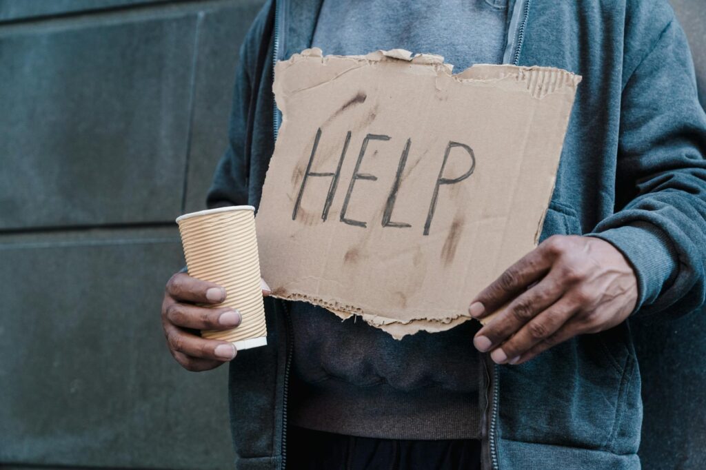 A close-up of hands holding a 'Help' sign, symbolizing the need for support related to financial assistance grandfamilies Utah