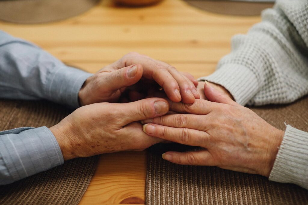 A close-up of hands holding a child and an elderly person's hands together. — resources for grandfamilies in Utah
