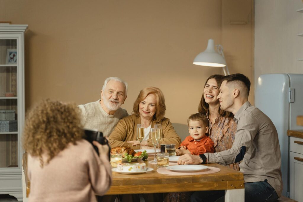 A family gathering where grandparents, parents, and grandchildren are enjoying a meal together, showcasing unity and suppo…