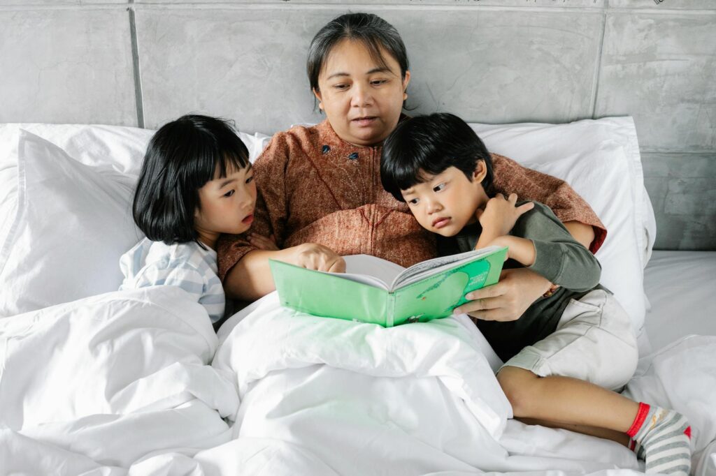 A grandmother reading a book with her grandchildren to provide comfort. — professional help grandchildren divorce