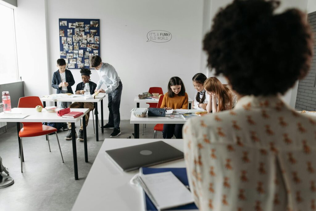 A group of happy grandchildren engaged in a classroom setting, illustrating diverse education options for grandfamilies in…