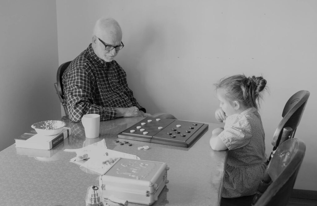 A happy child engaged in a routine activity such as reading or playing a game with a grandparent. — routine grandchildre…
