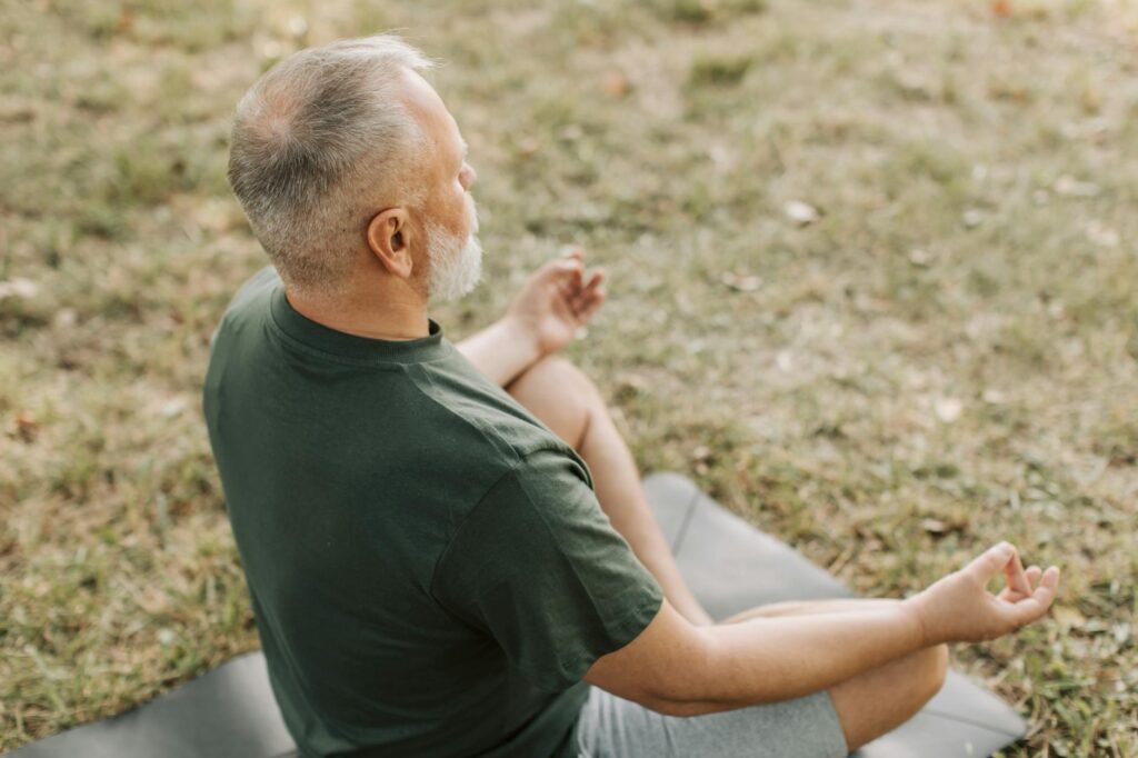 A serene outdoor scene where a grandparent practices self-care, representing the need for personal well-being. — emotion…