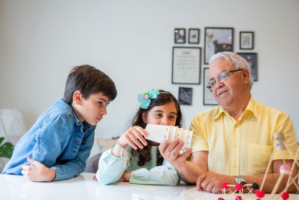 Grandparents and grandchildren participating in a fun science workshop at a community center. — community events grandfa…