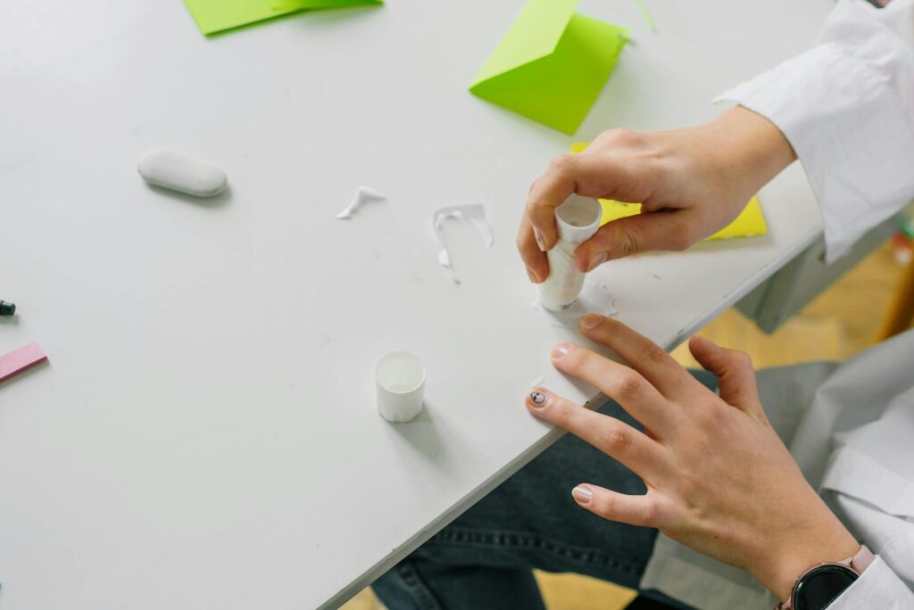 A close-up image of a child's hands creating a craft project with their grandparent. — benefits of grandparents Utah