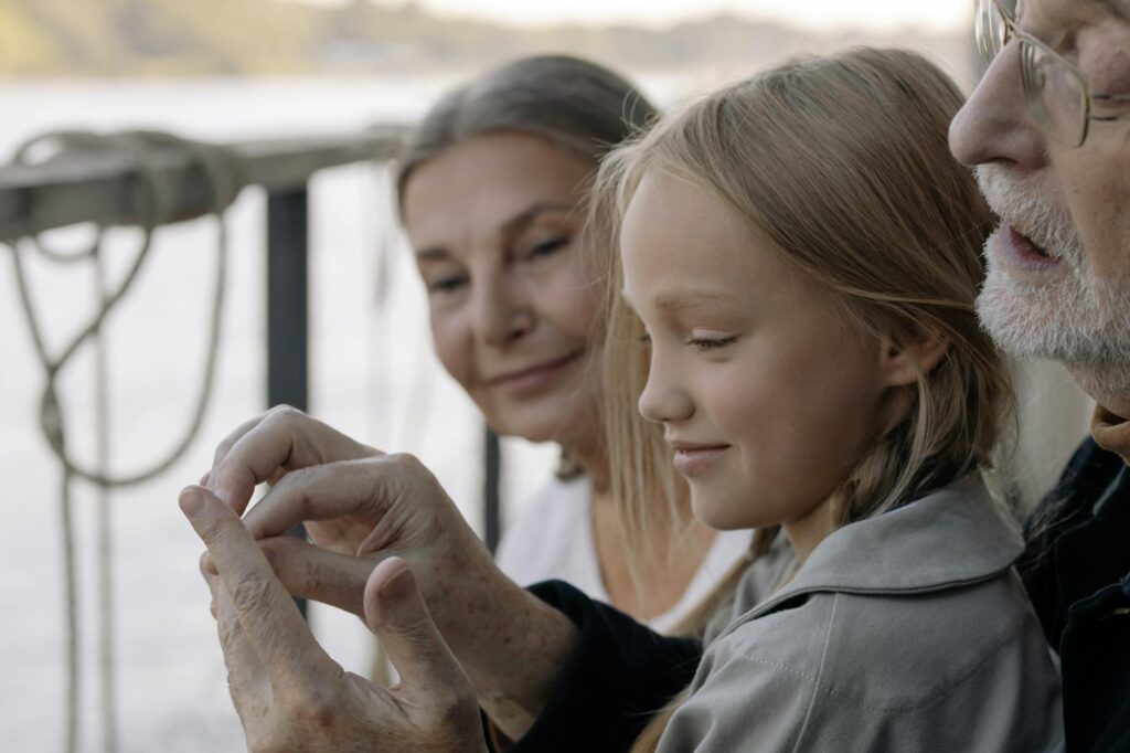A close-up of grandparents engaging in a fun activity with their grandchildren, illustrating emotional support for grandpa…