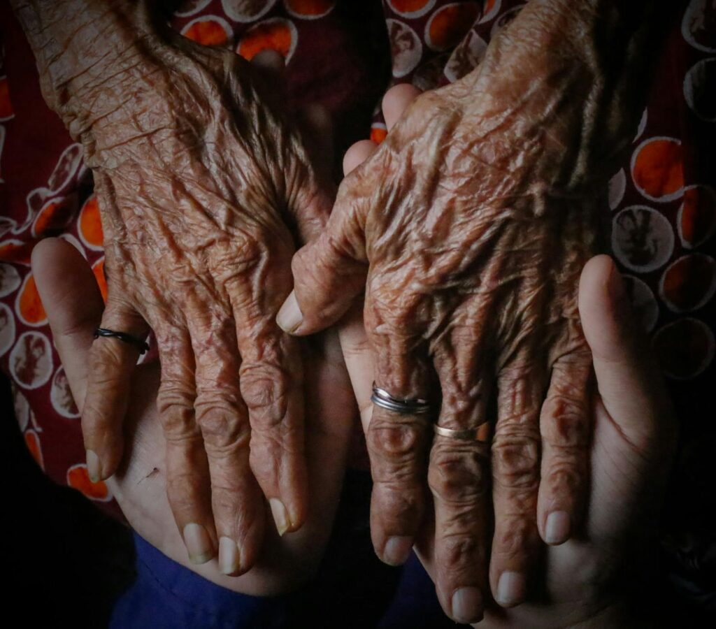A close-up of hands holding a child’s hand, symbolizing kinship care. — financial assistance grand families Utah