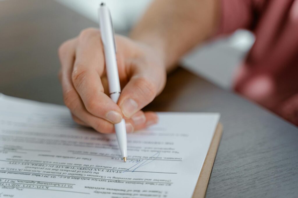 A close-up of hands signing legal documents, representing the guardianship process. — legal issues grand families Utah
