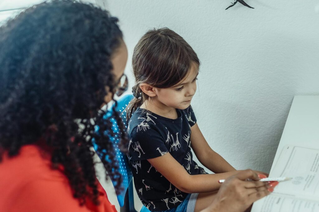 A tutor working one-on-one with a child in a cheerful learning space. — educational resources grand families Utah