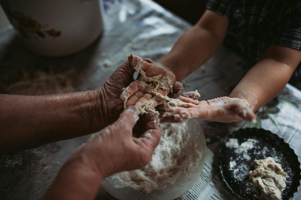 An elderly grandparent and a child enjoying a baking session together in the kitchen. — benefits of grandparents Utah