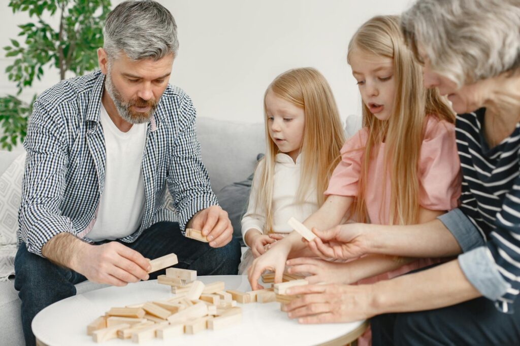 An outdoor family gathering with grandparents playing games with children in a park setting. — benefits of grandparents …